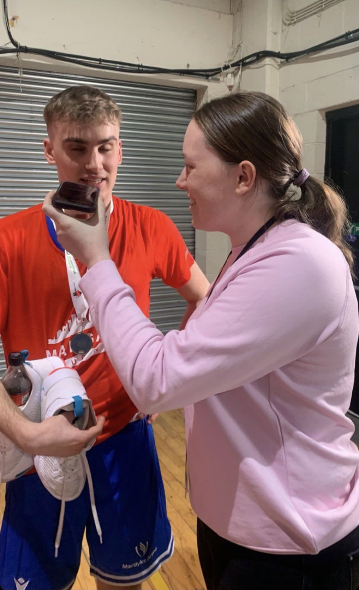 Orla courtside, recording an interview with a player after a final